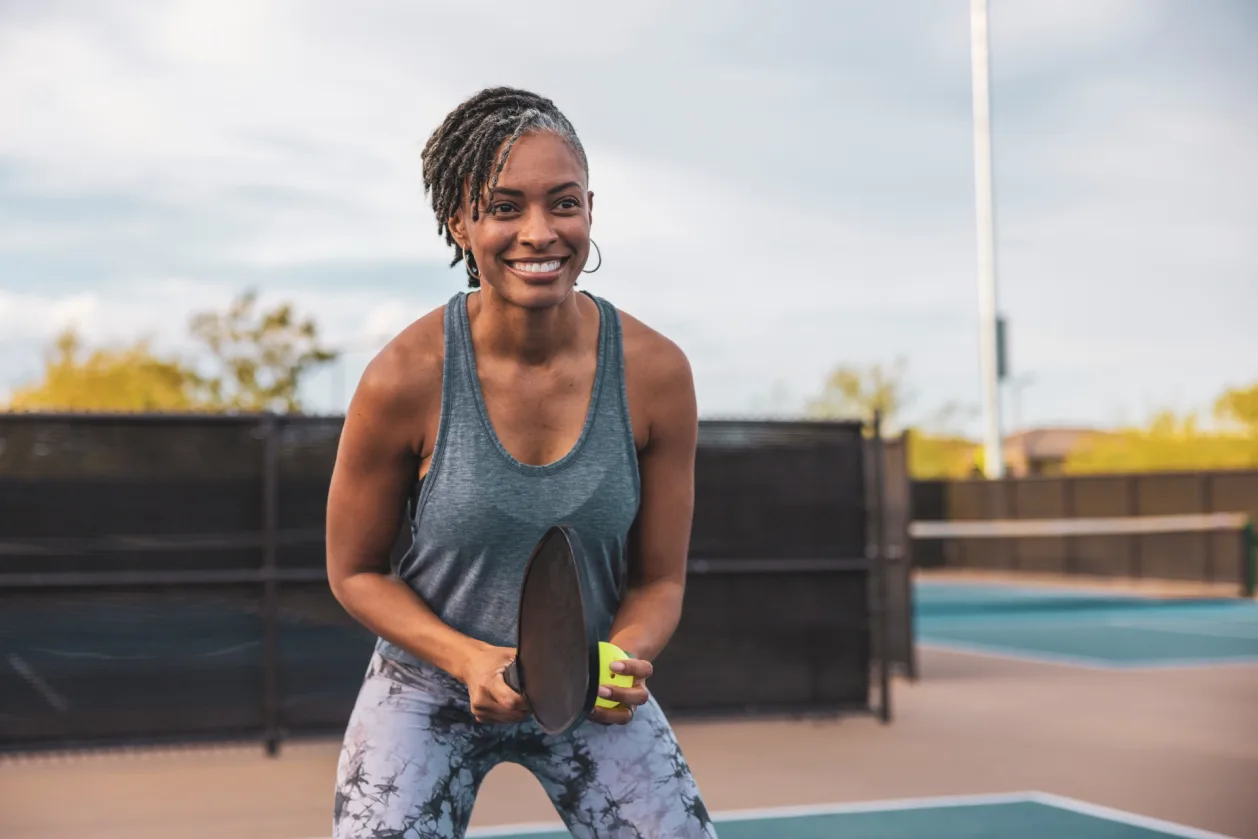 woman of color on pickleball court
